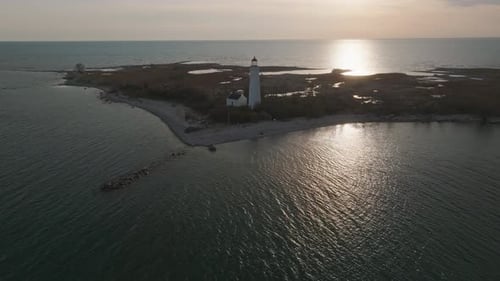 A serene lighthouse on a small island in lake huron at sunset, aerial view