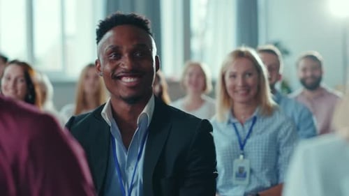 Smiling Man at Conference Applauds Speaker