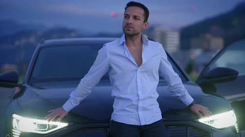 A Stylish Man Is Posing Confidently By a Luxury Car Against the Background of Twilight Sky