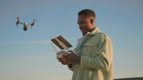 A Man Skillfully Operating a Drone in a Beautifully Scenic Outdoor Setting with Mountains