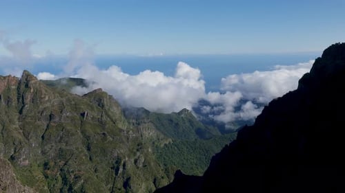 Expansive Sky and Distant Ocean Behind Rugged Mountain Range