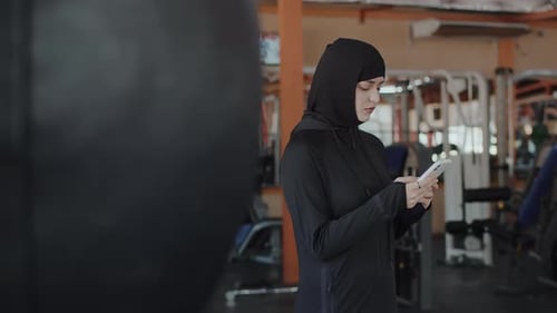 Woman Using Phone at the Gym