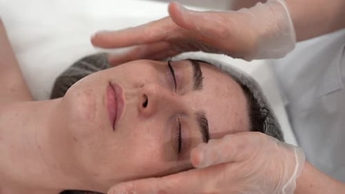 The Cosmetologist Makes Massage to the Client Face Makes Procedures in the Spa or Salon Closeup Skin