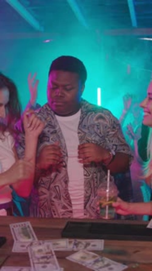 Excited Man Celebrates with Friends at Lively Bar