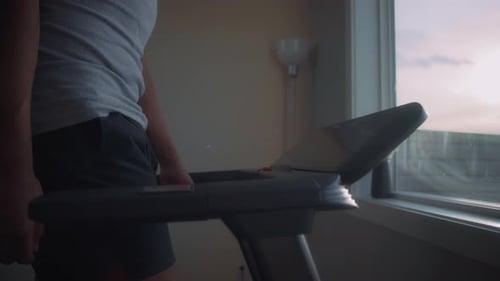 Close up of a man walking on a treadmill at home