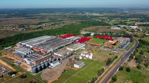 Aerial view of industrial buildings at the suburb of the city, next to forest and nature.