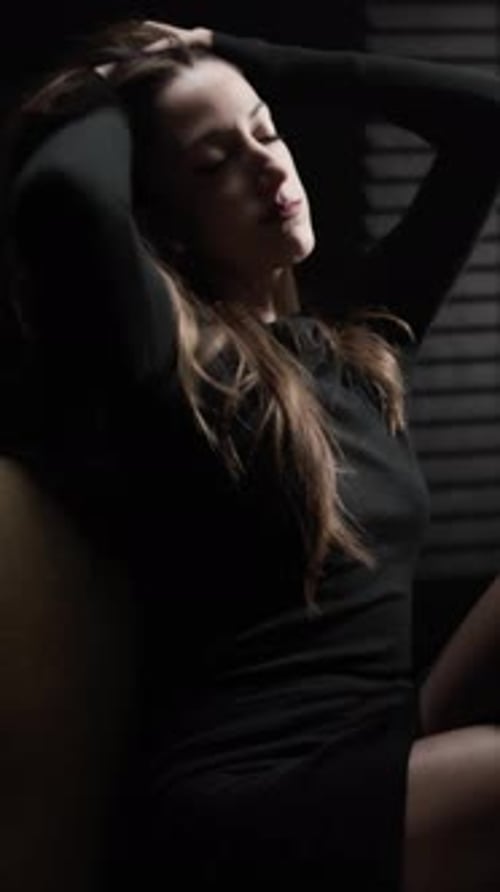 Sensual Woman Posing in Dark, Moody Setting