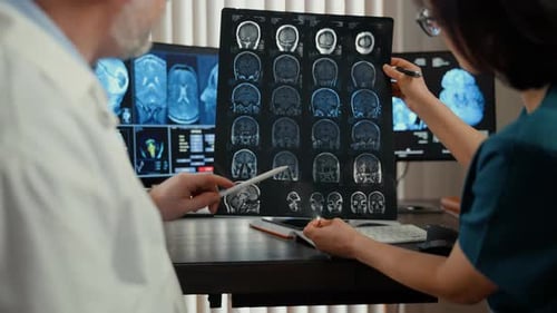 Doctor Analyzing Brain MRI Scans on Multiple Monitors in Modern Clinic Advanced Neuroimaging