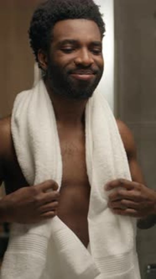 Confident Man Admiring Himself After Shower in Bathroom