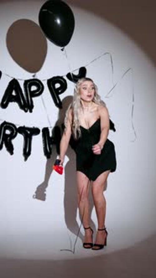 Woman Celebrates Birthday with Balloons and Party Popper
