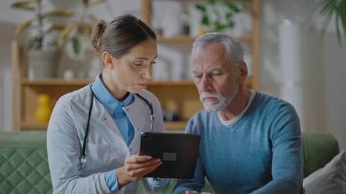 Doctor Explains Medical Information on Tablet to Patient