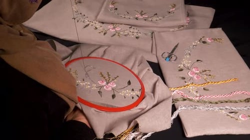 Woman Embroidering Floral Design on Linen Fabric