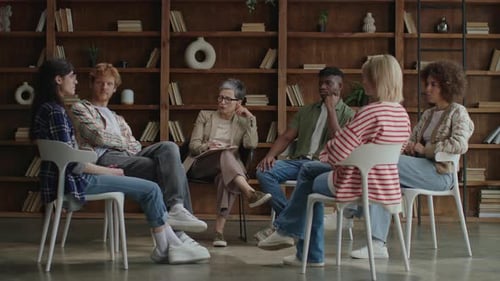 Group of 6 Diverse Adults Talking in Circle During Therapy Session
