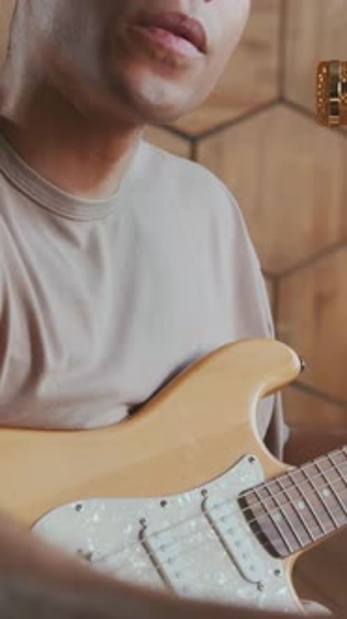 African American Man Guitarist Comes Up with Music and Making Notes on Notepad