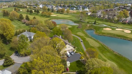 Large houses in country club neighborhood on bright spring day. Aerial hyperlapse revealing pristine