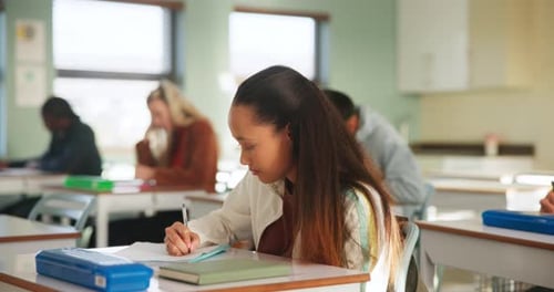 Students Writing at Desks in Classroom
