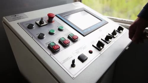 Un panel de control industrial que cuenta con una interfaz de pantalla táctil y botones físicos en stock