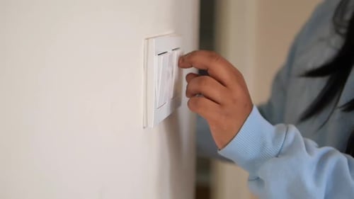 a Child is Reaching Out to Turn on the Light Switch in Their Room