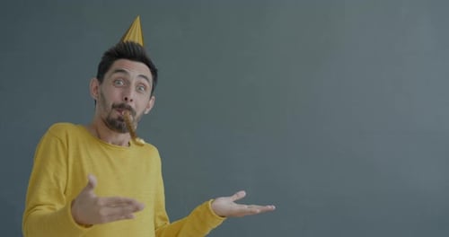 Man Celebrates with Party Blower Wearing Yellow Sweater
