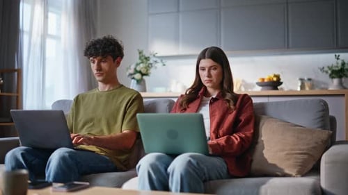Home Sweethearts Browsing Laptops at Soft Couch Place Young Couple Working