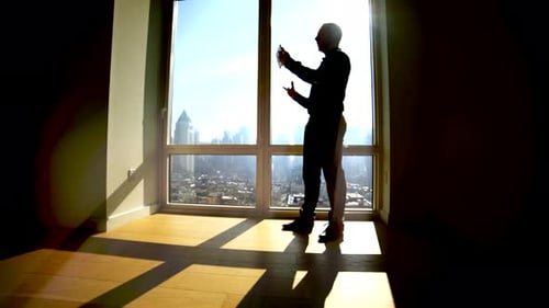 Young Successful Man Living in High Rise City Apartment With Skyline View