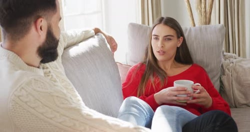 Woman Talking to Man on Sofa at Home
