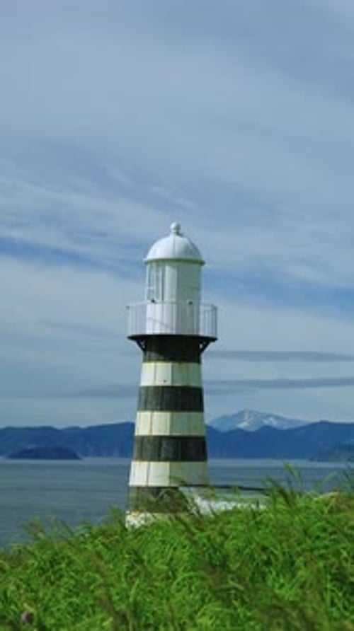 A Majestic Lighthouse Standing Tall on the Cliffside Overlooking the Expansive Sea with Stunning