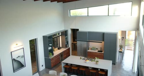 Modern kitchen with island, dining table, and bar stools in contemporary home, copy space