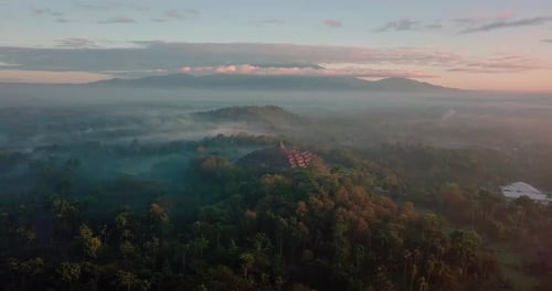 birds eye view over the borobudur temple and surrounding mountains at sunrise