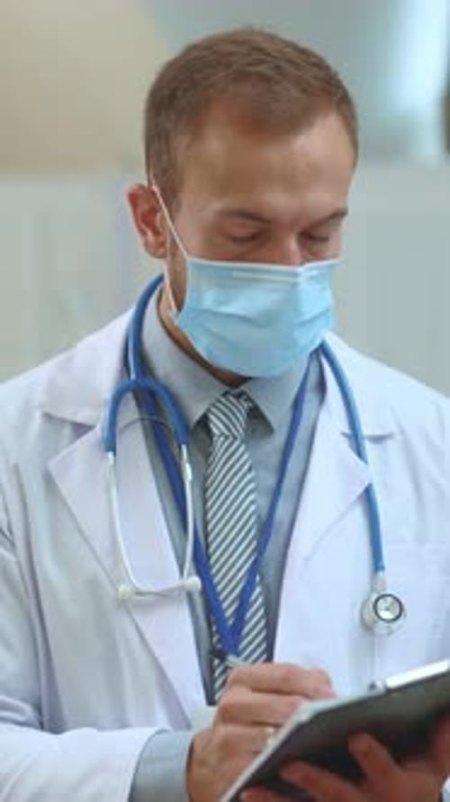 Retrato de un joven médico generalista profesional en bata blanca con máscara médica