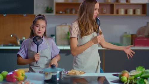 Mother and Daughter Silly Dancing in Kitchen