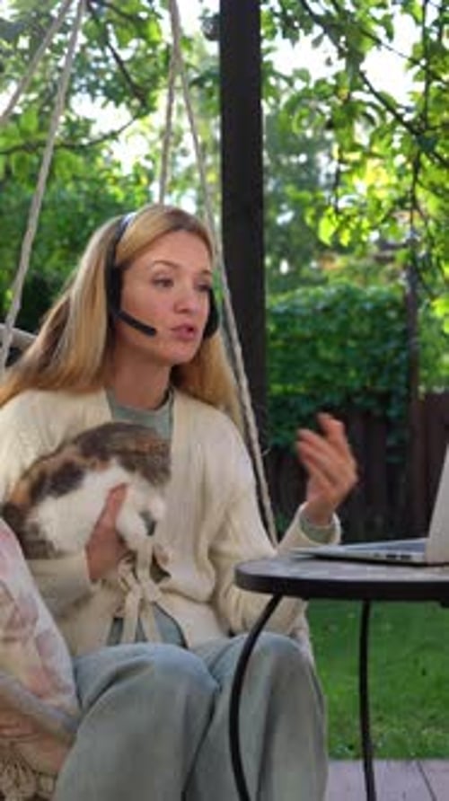 Woman Talking on Laptop with Cat in Garden
