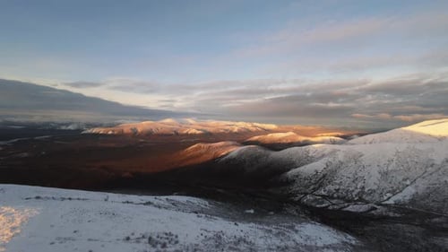 Snowy Mountains Illuminated by Golden Sunrise Light