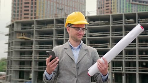 Construction Engineer Displaying Green Screen on Mobile Phone