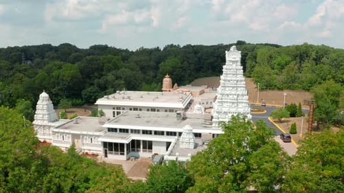 Vue aérienne par Drone du côté d'un temple hindou du sud de l'Inde entouré d'une forêt verdoyante pendant la journée.
