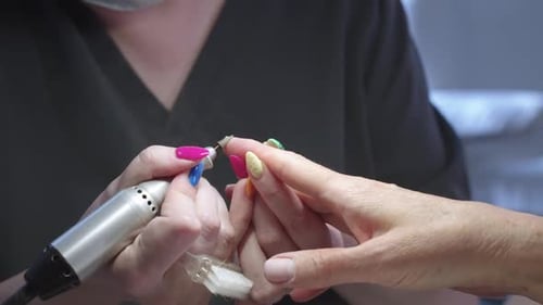 Nail Technician Shaping Colorful Fingernails
