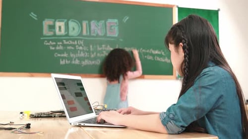 Asian girl writing engineering prompt by using AI software at class. Pedagogy.