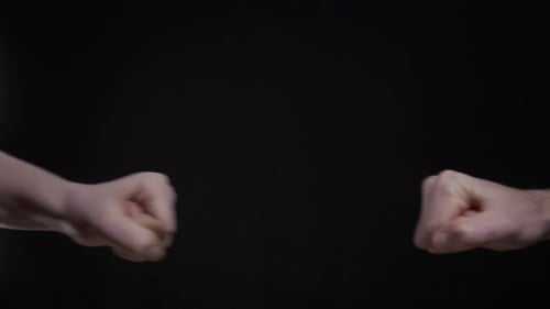 Fist Bump Between Two People on Black Background