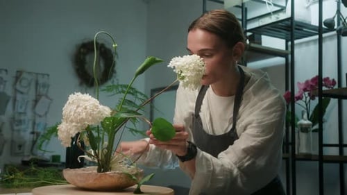 Woman Arranging White Flowers in Floral Shop