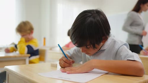 Adorable student learn with teacher in classroom at elementary school.