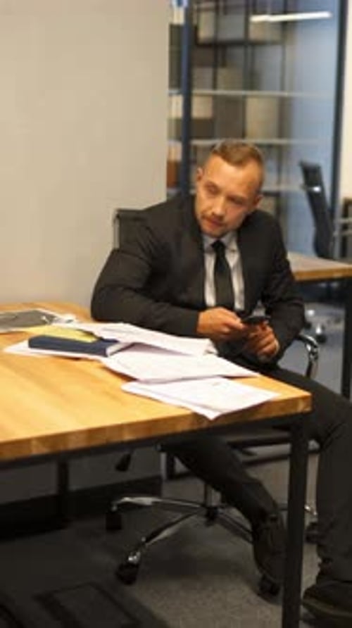 Vertical d'un patron travaillant avec des documents que sa secrétaire lui apporte