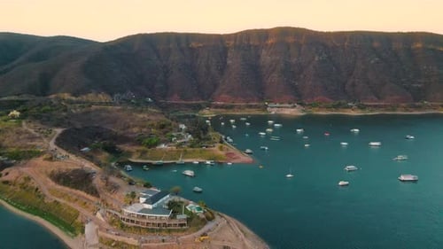 Aerial drone flying over a lake, water dam, with mountains at sunrise. Beautifull dreamy landscape