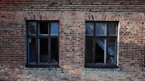 Zerstörte Schule und zerbrochene Fenster im Gebäude, echter Krieg in der Ukraine