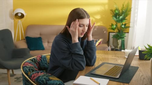 Young Woman Working at Home Experiencing Stress