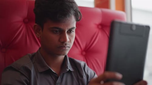 Young Adult Using Tablet Device Indoors Close Up
