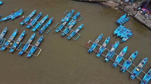 Vista aérea Cinemática de los barcos de pesca Blue Outrigger atracados en un puerto costero