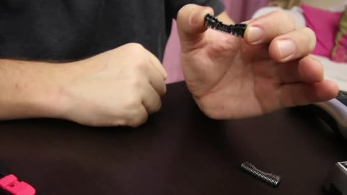 Man Disassembling Electronic Part on Table