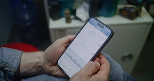 Man Making Investments During Working Day in Workshop Combining Job with Online Trading