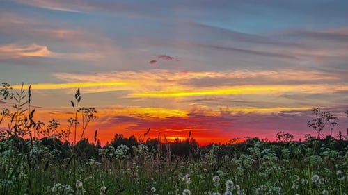 Dramatic view of colorful cloudy sky during golden hour showing shooting star passing through. Time