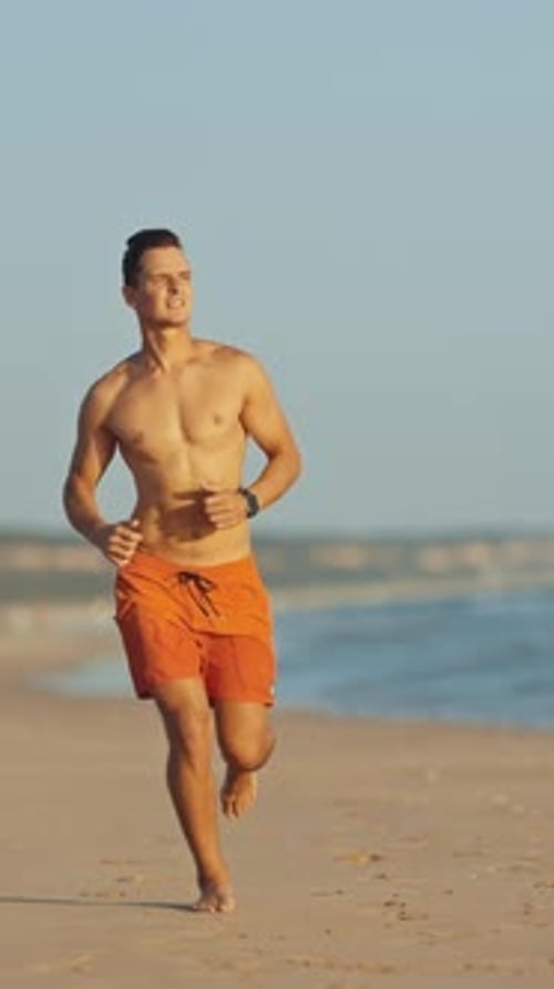 Young Athletic Lifeguard Running on the Beach